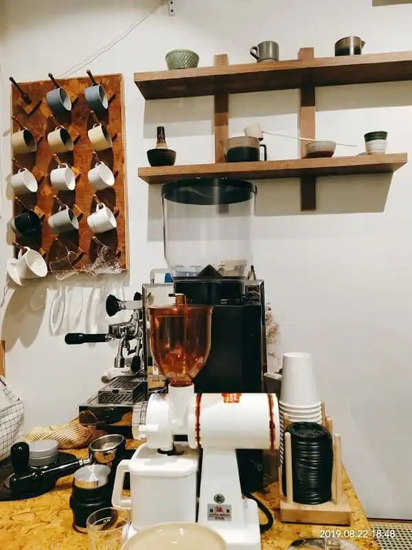 Coffee machine with coffee cups hanging in the background