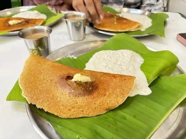 Dosa and Idli served on banana leaf, traditional south Indian dish