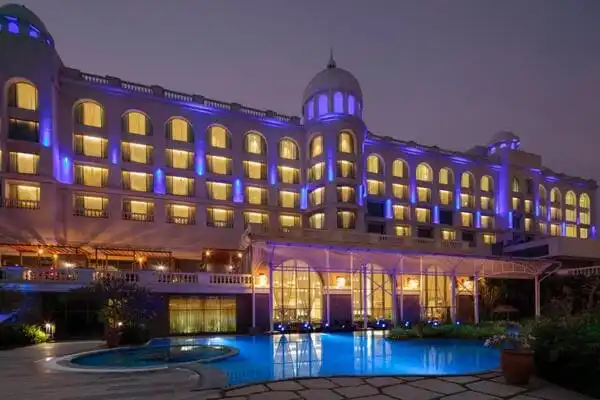 Exterior night shot of a 5 star hotel with the swimming pool seen in the front