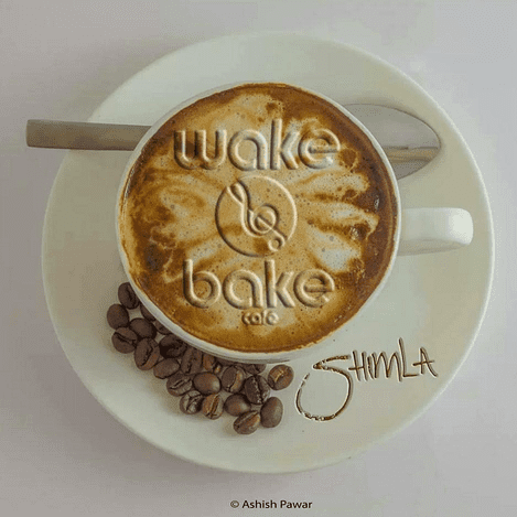 coffee cup with latte art spelling out wake and bake