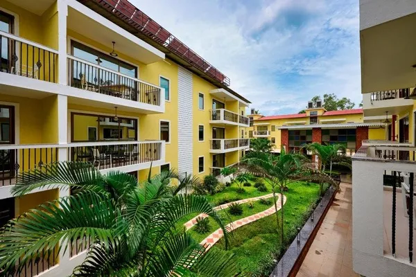Hotel building in monsoon, with a small park in between.