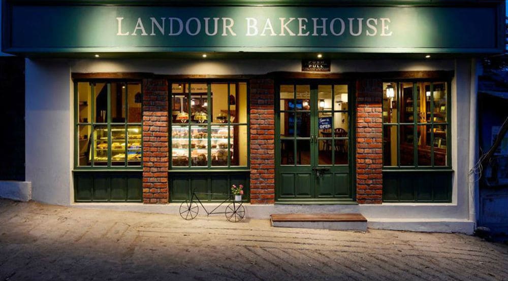 In front of the bakehouse, board says the title of the cafe