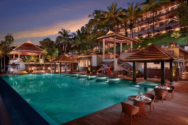 Luxurious hotel exterior with vibrant lighting and a swimming pool